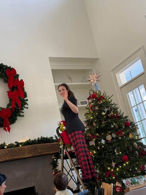 AIFS Teilnehmerin während ihres Aufenthalts als Au Pair in den USA beim Schmücken eines Weihnachtsbaums