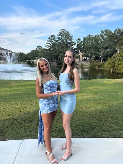 Eine AIFS-Austauschschülerin steht mit einer Freundin während ihres Auslandsjahrs in den USA am Abends des Homecoming-Balls vor einem Brunnen